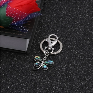 Macro shot of dragonfly keychain with colorful abalone shell wings and crystal accents