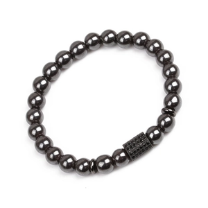 Macro shot of hematite beaded bracelet featuring a micro-pave black crystal cylinder charm