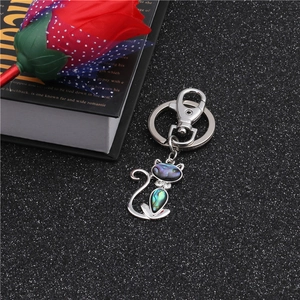 Detailed close-up of a cat keychain featuring natural abalone shell inlay on black background