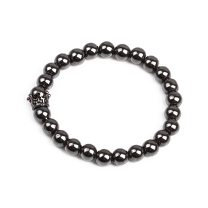 Detail shot of magnetic hematite beads and a micro-paved crown charm on the men's bracelet
