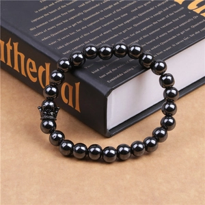 Detail of magnetic hematite beads and black zircon crown charm on beaded bracelet for men