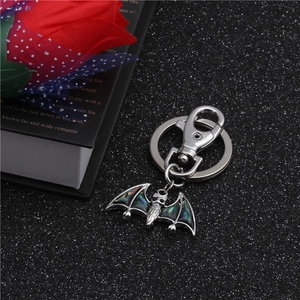 Macro detail of bat-shaped keychain with colorful abalone shell inlay and metal lobster clasp