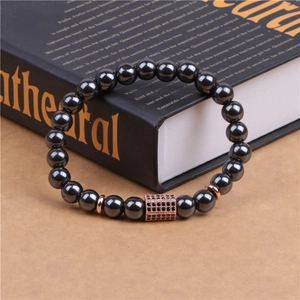 Macro detail of magnetic hematite beads and rose gold plaque with black micro-inlaid stones