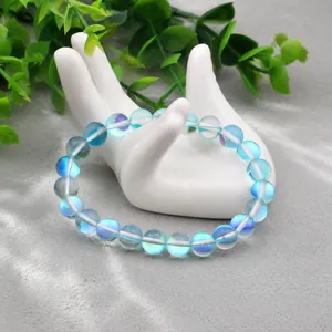 Vue détaillée du bracelet en perles de verre bleu iridescent sur un support de main blanc