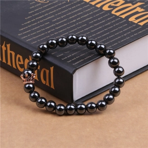 Detail of magnetic black stone beads and rose gold crown charm with micro-zirconia inlay