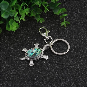 Detailed turtle keychain pendant with iridescent abalone shell inlay and silver metal finish