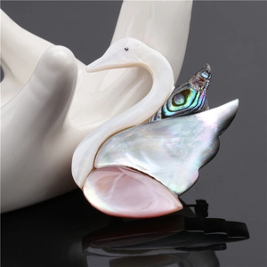 Détail d'une broche cygne avec incrustations d'abalone, de nacre et de coquille rose