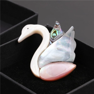 Détail d'une broche cygne élégante avec incrustation de nacre sur velours noir