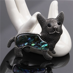 Elegant silver dog brooch featuring natural abalone shell inlay on a white hand stand