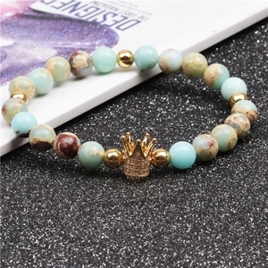 Detail shot of emperor stone beaded bracelet with golden crown charm and inlaid diamonds