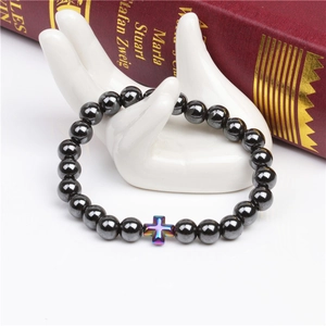 Close-up of 8mm hematite beads bracelet featuring a rainbow iridescent cross bead on a hand model