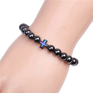 8mm black magnetic hematite beaded bracelet with iridescent blue cross charm on wrist