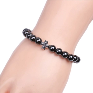 Detail view of 8mm black magnetic beads bracelet with a silver metal cross for men
