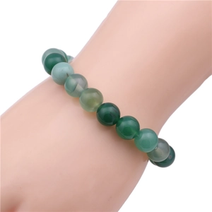 Detail of 10mm green agate beaded bracelet with natural stone textures on model wrist