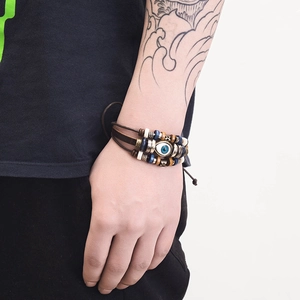 Detail of multi-layer leather bracelet with evil eye charm and vintage beads on wrist
