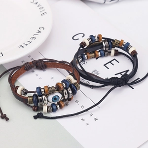 Close-up of woven leather evil eye bracelets with beads and adjustable cord on a white plate