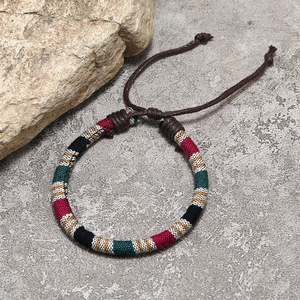 Detailed shot of Bohemian woven cotton friendship bracelet on a stone surface