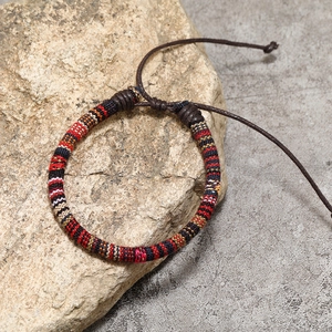 Detail of colorful hand-woven ethnic cotton bracelet on a natural stone background