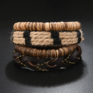 Detail of vintage 4-piece multilayer leather bracelet set with wood beads and rope textures