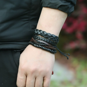 Macro shot of men's vintage layered leather bracelets featuring woven styles and black beads