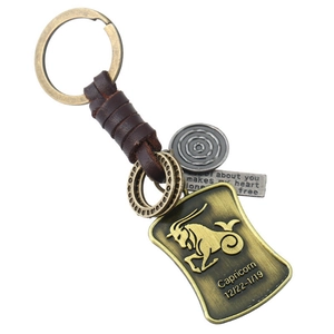 Détail macro du porte-clés Capricorne vintage en cuir avec pendentifs en bronze