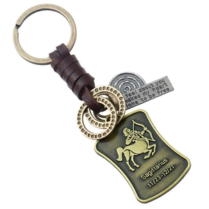 Détail du porte-clés Sagittaire en cuir avec breloque en bronze et date du zodiaque