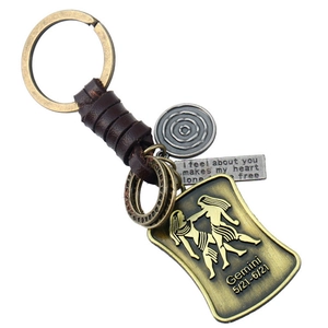 Vue macro du porte-clés rétro Gémeaux en cuir avec pendentif en bronze et détails alliage