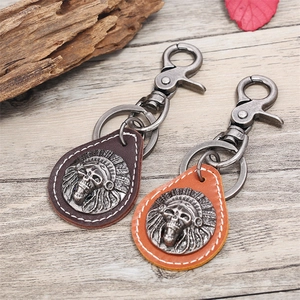 Retro punk genuine leather keychain with eagle skull metal logo on vintage wood background