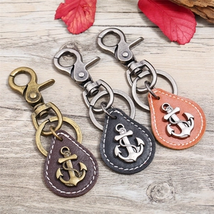 Close-up of vintage nautical anchor leather keychains in black, brown and orange colors