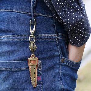 Retro punk bronze saw keychain with leather detail and multi-rings on denim jeans