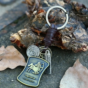 Détail du porte-clés zodiaque Sagittaire vintage avec pendentifs en bronze et cuir tressé