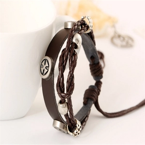 Bracelet multi-rangs en cuir tressé vintage avec breloques de croix sur tasse blanche