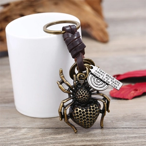 Vintage-Spinne-Schlüsselanhänger aus Bronze mit Lederband und Gravuranhänger an einer Tasse
