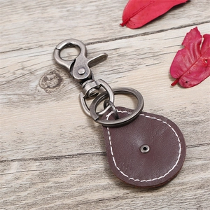 Retro brown cowhide leather keychain with star alloy pendant on wooden background