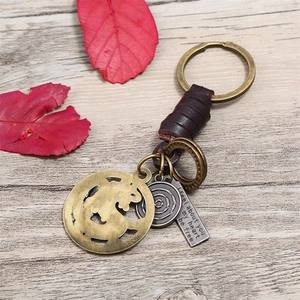 Handmade vintage leather keychain with bronze pendants and autumn leaf decoration