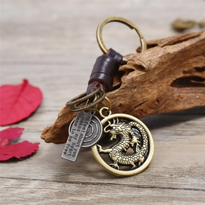 Vintage braided leather keychain with brass dragon medallion and engraved metal pendant