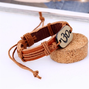Bracelet rétro en cuir tressé marron avec symbole Om en bronze sur socle blanc