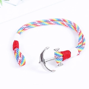 Detailansicht eines silbernen Ankeranhängers an einem bunt geflochtenen nautischen Armband