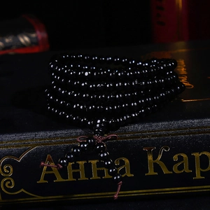 Bracelet bouddhiste multi-tours en bois de santal noir sur un livre vintage