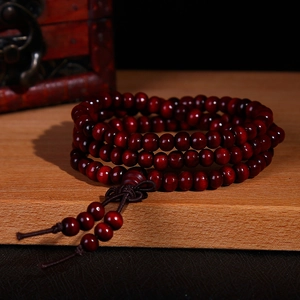 Gepolijste sandelhouten kralenarmband met traditionele knoop en kwastjes decoratie