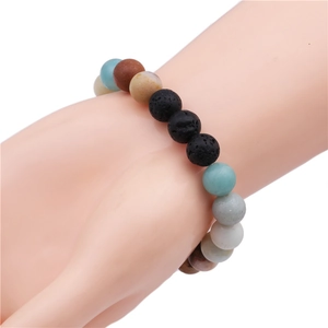 Macro shot of 10mm malachite and lava stone beaded bracelet worn on wrist model