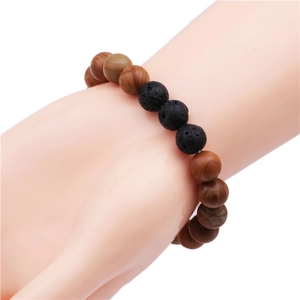 Close-up of beaded bracelet featuring brown wood textures and black lava stone beads