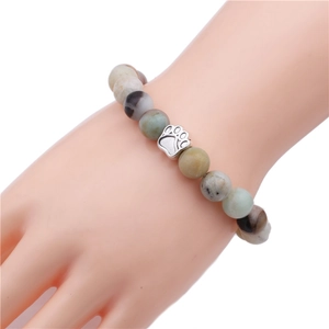 Detail of 10mm natural stone beaded bracelet with a silver paw print charm pendant