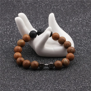 Detail of wooden beads and black lava rock bracelet with dark grey metal dumbbell