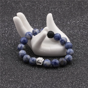 Detailed shot of 10mm blue marble beads bracelet with silver paw charm on hand display