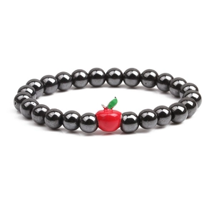 Magnetic hematite beaded bracelet with a red apple charm on a clean white background