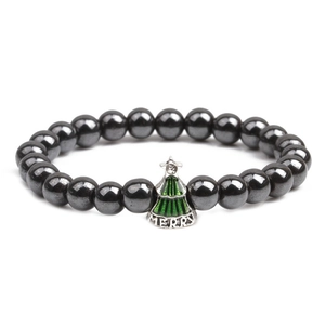 Magnetic hematite bead bracelet featuring a green enamel Christmas tree pendant with Merry text