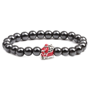 Detail of hematite bead bracelet with red enamel Santa Claus sleigh charm on white backdrop