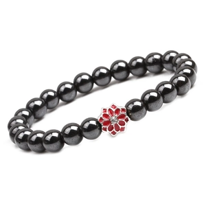 Detail of hematite bead bracelet with red enamel flower and sparkling center crystal