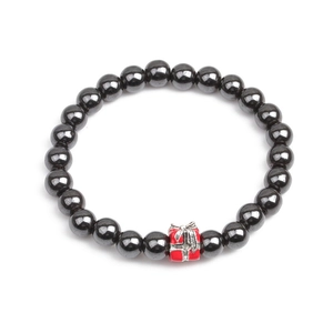 Detail of hematite beaded bracelet featuring a red Christmas gift box charm on white background